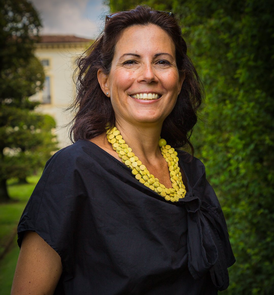 Debora Conti sorridente in un parco, con una collana gialla